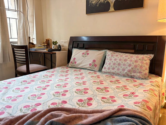 Emenaura Blossom Garden cotton bedsheet featuring floral print in soft pastel colors, neatly spread on a bed.
