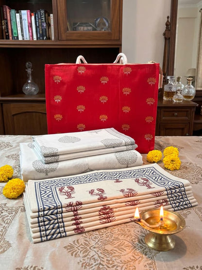 Emenaura Grand Festive Home bed sheet set with firefly Gemini flash design and six matching cotton placemats, folded in front of the bag.