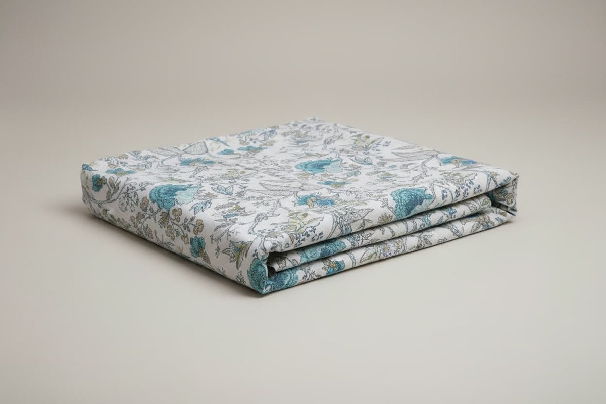 Folded Emenaura hand-block printed cotton bedsheets with festive designs, showcasing intricate patterns and soft fabric.