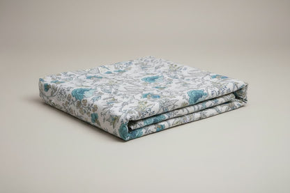 Folded Emenaura hand-block printed cotton bedsheets with festive designs, showcasing intricate patterns and soft fabric.