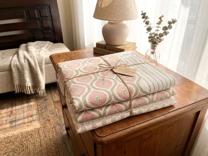 Folded Emenaura blush geometric cotton bedsheet set showing soft fabric with a modern geometric pattern.