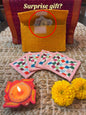 Set of four Emenaura Diwali-themed coaster set with a surprise gift in a pouch, featuring vibrant decorative designs.