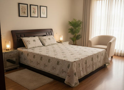 Emenaura festive bed sheet set with hand-block printed design and two embroidered cushion covers on a cozy bedroom bed.