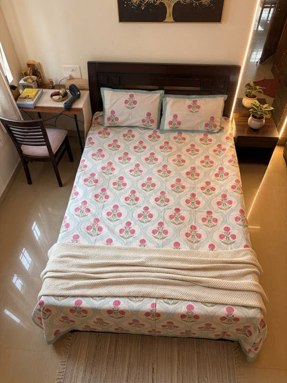 Emenaura Blossom Garden cotton bedsheet with floral pattern, shown from an overhead view on a bed.