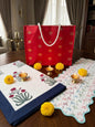 Red percale bed sheet set and matching table runner by Emenaura, showcasing elegant festive home decor.